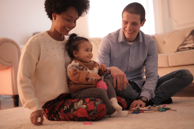rodina, žena, muž, a dítě, sedí doma na zemi na koberci